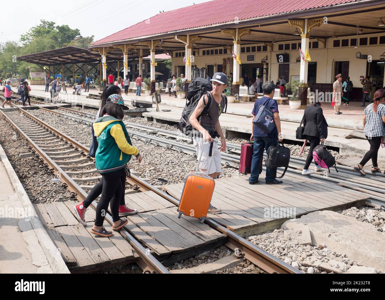 Passagiere, die die Gleise überqueren, nachdem sie am Bahnhof in Ayutthaya Thailand angekommen sind Stockfoto