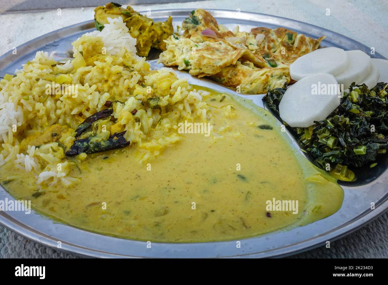 Kadi - Chawal oder Joghurt-Kururthali. Nordindische Speiseplatte. Reis, Salat und Omelette. Uttarakhand Indien Stockfoto