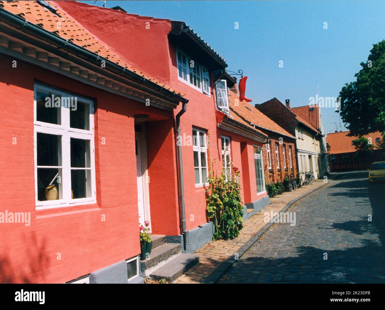 R…NNE Bornholm Dänemark Typische Stadtvillen in Ršnne mit Hollyhocks entlang der Außenwand Stockfoto