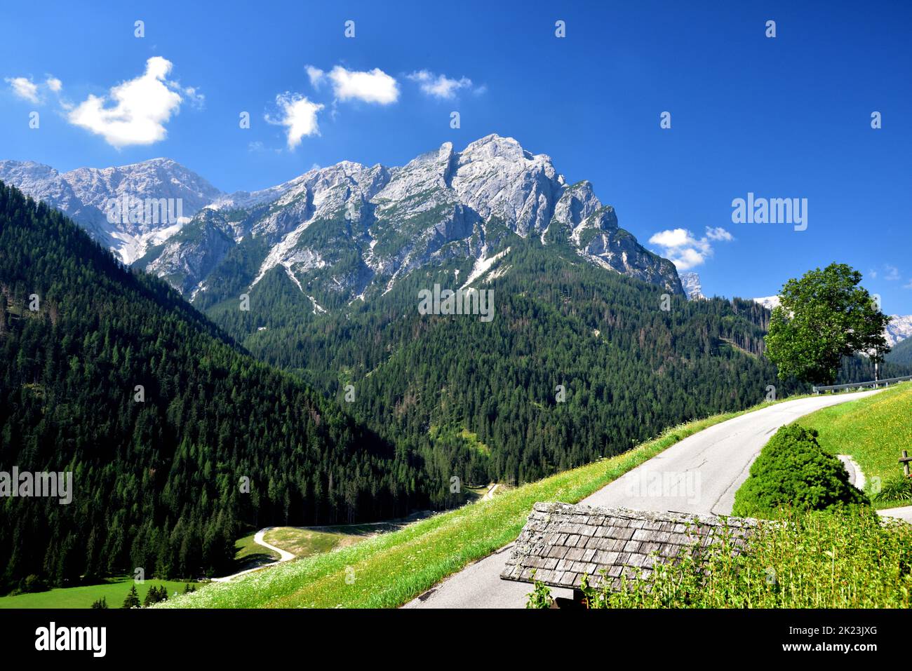 Eine lange, kleine bergauf-Straße, die sich rechts vom Pragistal schlängelt, bietet einen hervorragenden Blick auf den Sasso del Signore oder Herrstein Stockfoto