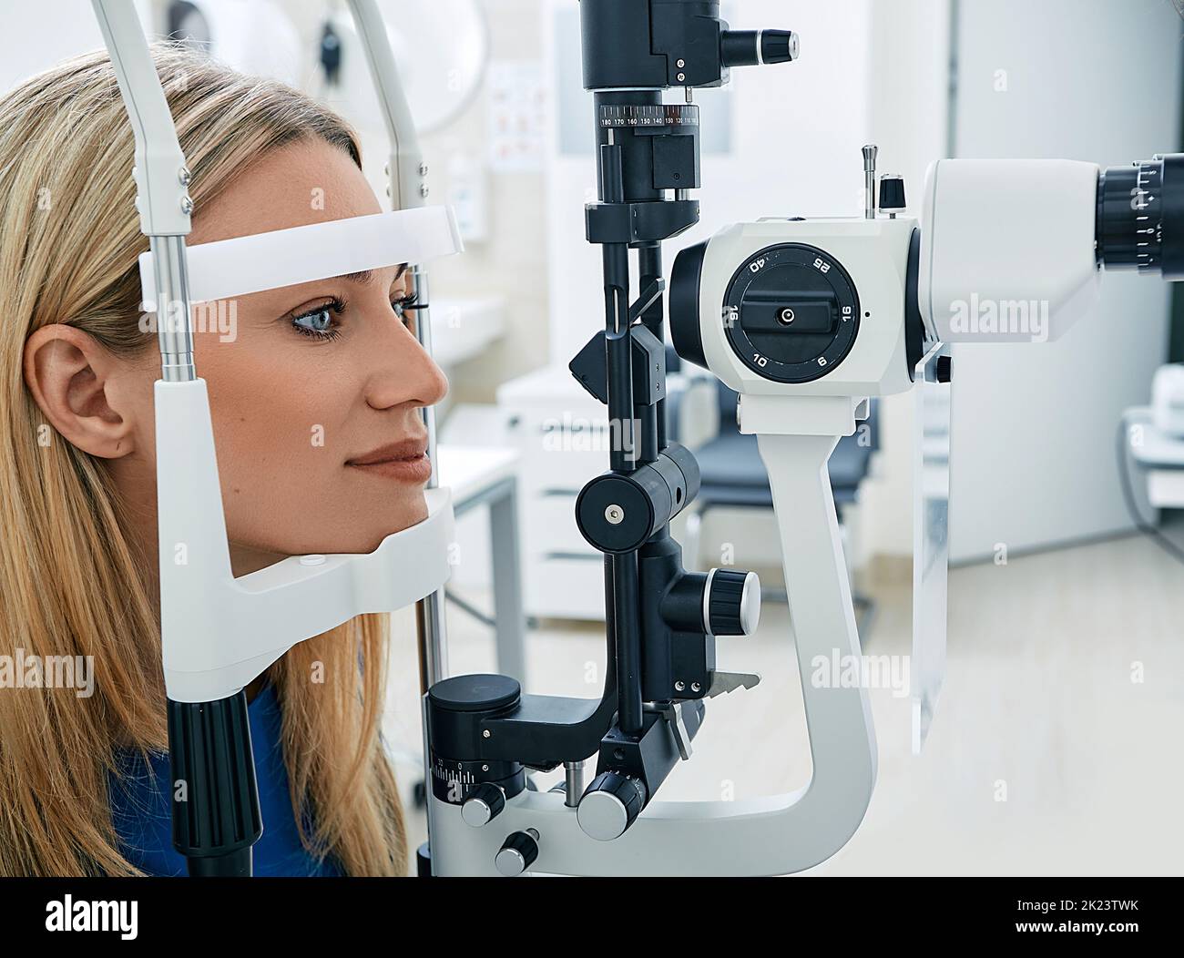 Frau erhält Sehtest mit binokularer Spaltlampe in der Augenklinik. Überprüfung der Netzhaut des weiblichen Auges, Nahaufnahme Stockfoto