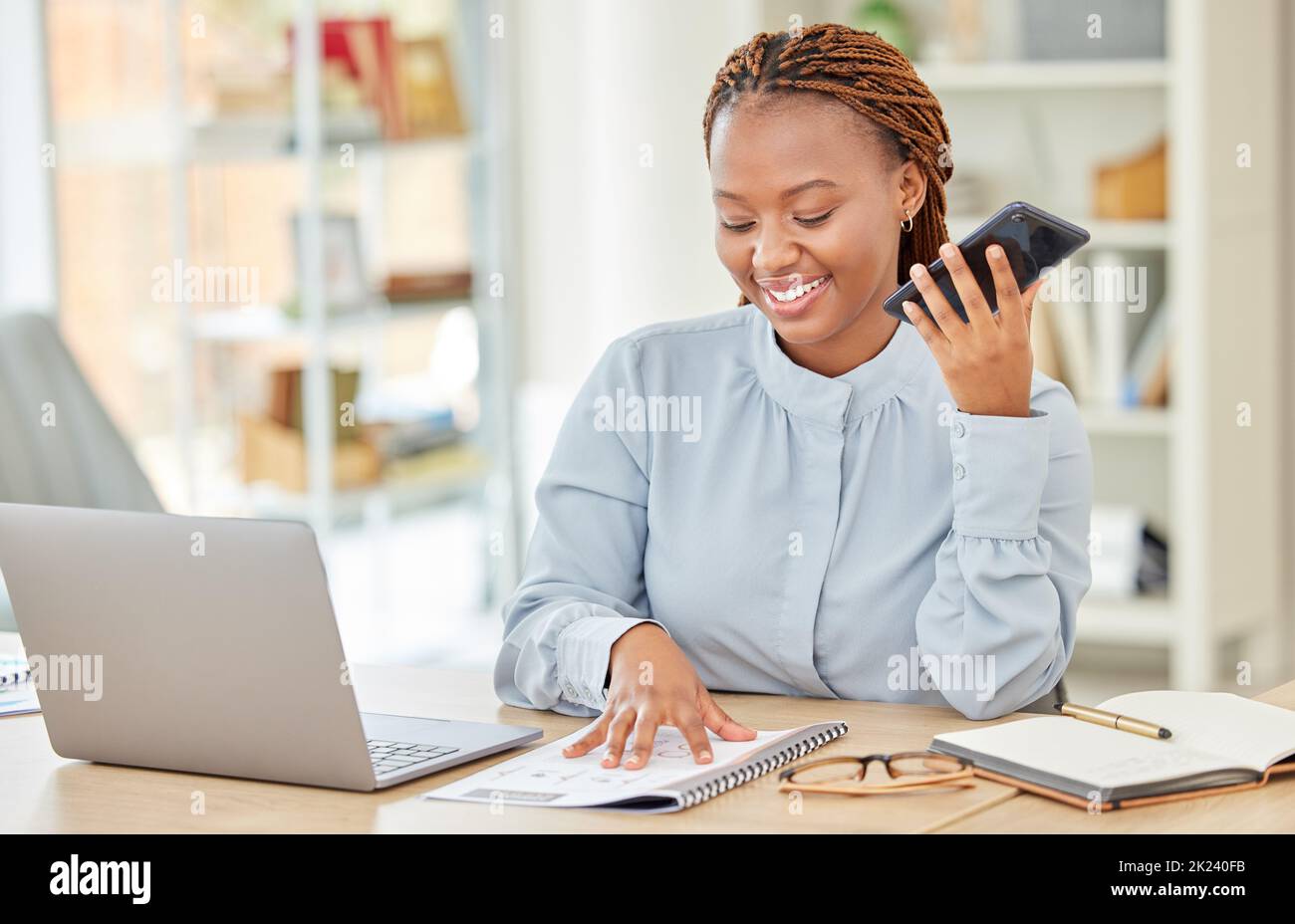 Professionelle Geschäftsfrau mit Telefonanruf, die Notebook auf ihrem Laptop-Computer im modernen Büro liest. Eine Angestellte der Firma, die am Schreibtisch sitzt und sich unterhielt Stockfoto