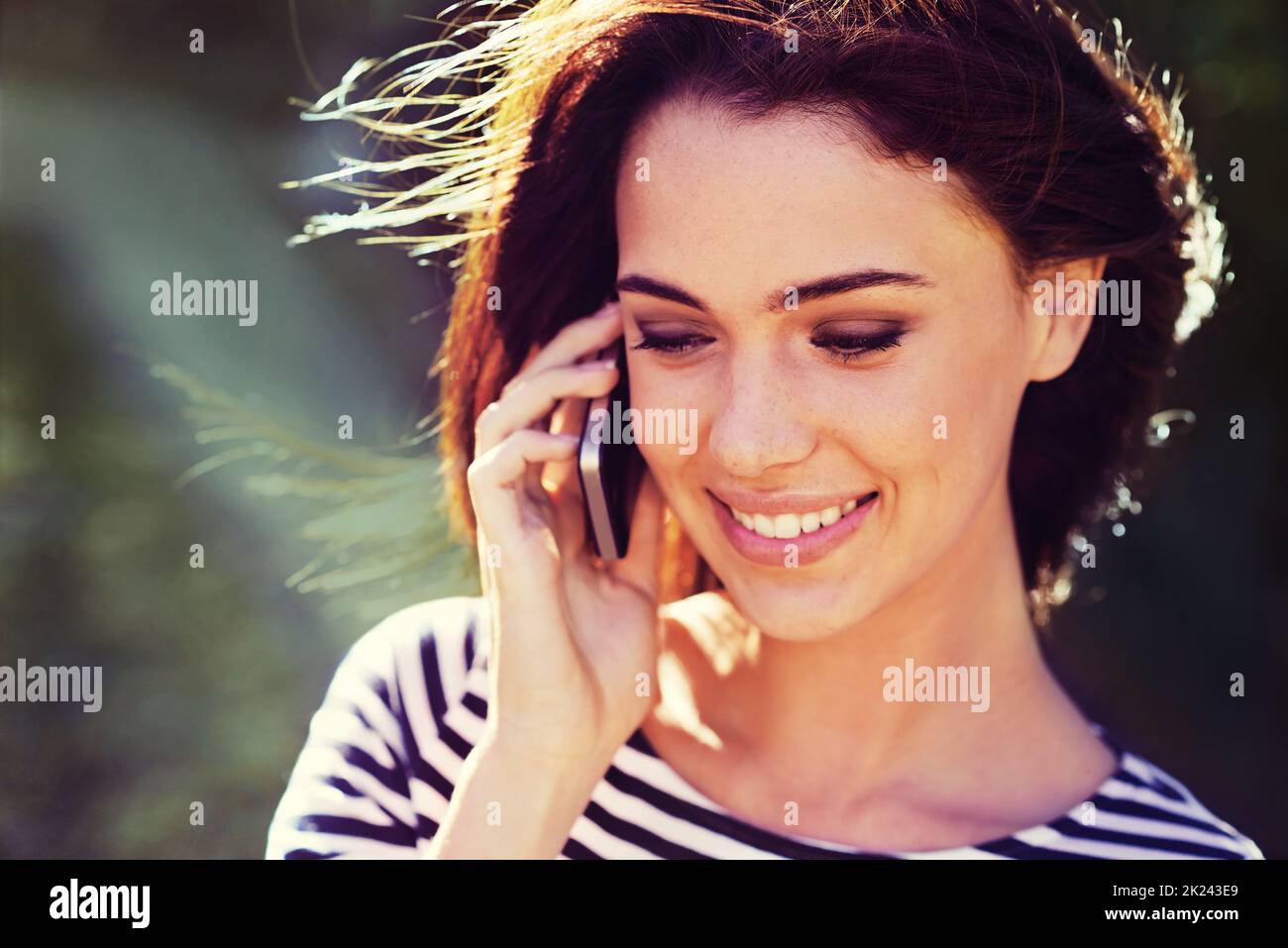 Es ist so schön, Ihre Stimme zu hören ... eine wunderschöne junge Frau am Telefon, während draußen. Stockfoto