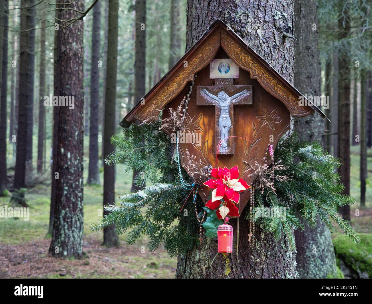 Gedenkkreuz auf einem Baumstamm im Wald Stockfoto