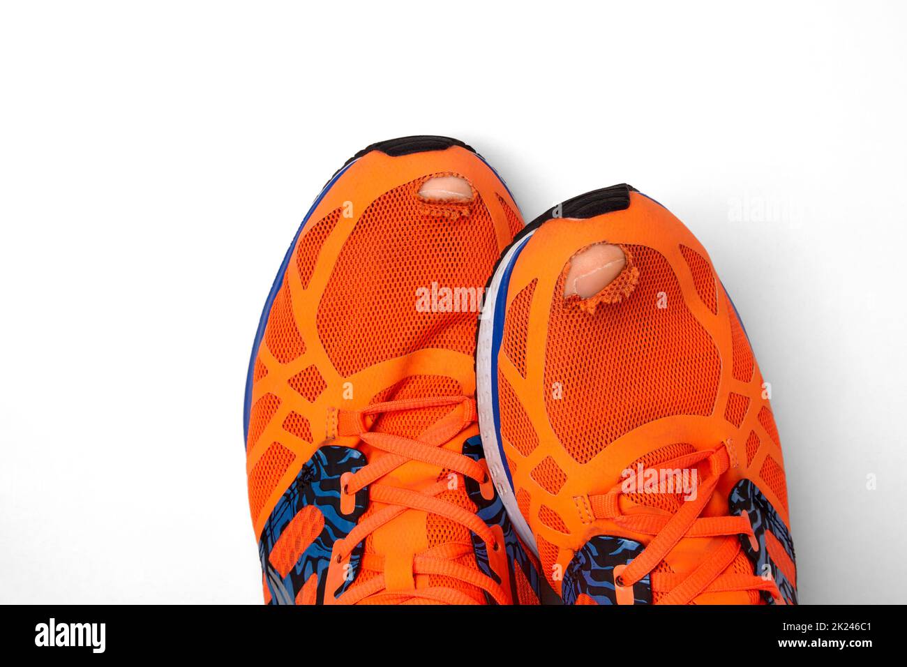 Abgenutzte, löchrige Sneaker, aus denen die Zehen isoliert auf weißem Hintergrund hervorstehen Stockfoto