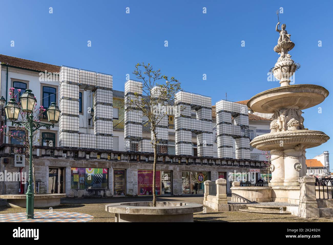 Ovar, Portugal - 18. Februar 2020: Weißer Plastikwasserbehälter, der aufgeschichtet wurde, um das Wort OVAR in Hauptstädten auf einem kleinen Stadtplatz zu schreiben, wo die Leute auf einem spazieren Stockfoto