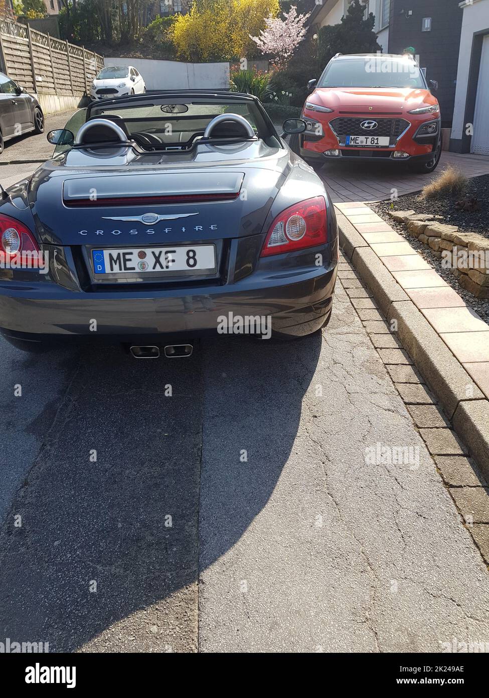 HEILIGENHAUS, NRW, DEUTSCHLAND - 28. MÄRZ 2020: Ein Hyundai Kona SUV und Chrysler Crossfire Roadster parken vor einem Haus Stockfoto