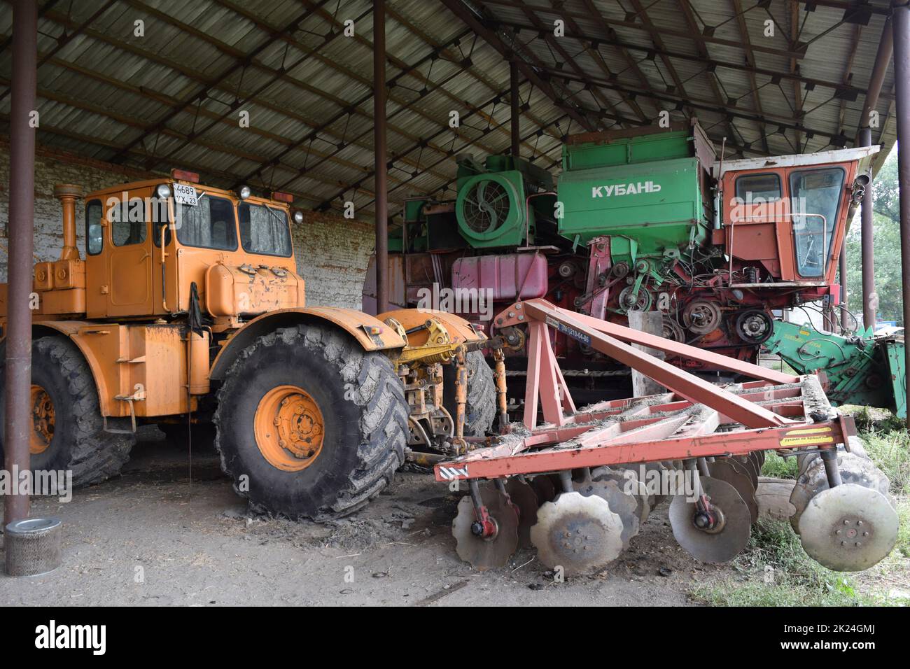 Russland, Poltavskaya Dorf - 6. September 2015: Großer Traktor mit Scheibenegge auf dem Anhänger. Mähdrescher. Landwirtschaftliche Maschinen. Stockfoto