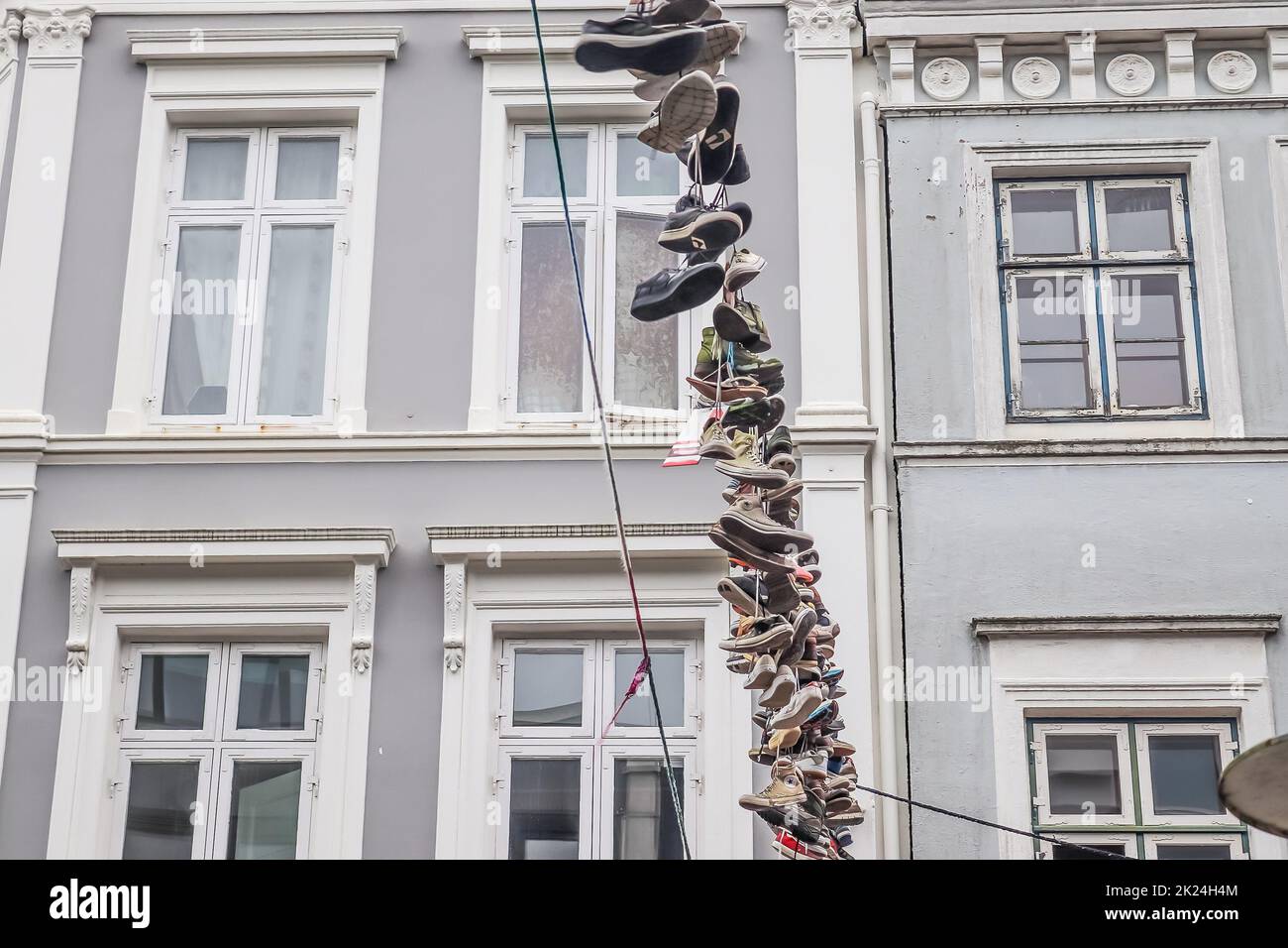 Flensburg, Deutschland, Dezember 16. 2020 - Schuhe hängen zwischen alten Häusern in der nördlichsten deutschen Stadt Flensburg Stockfoto