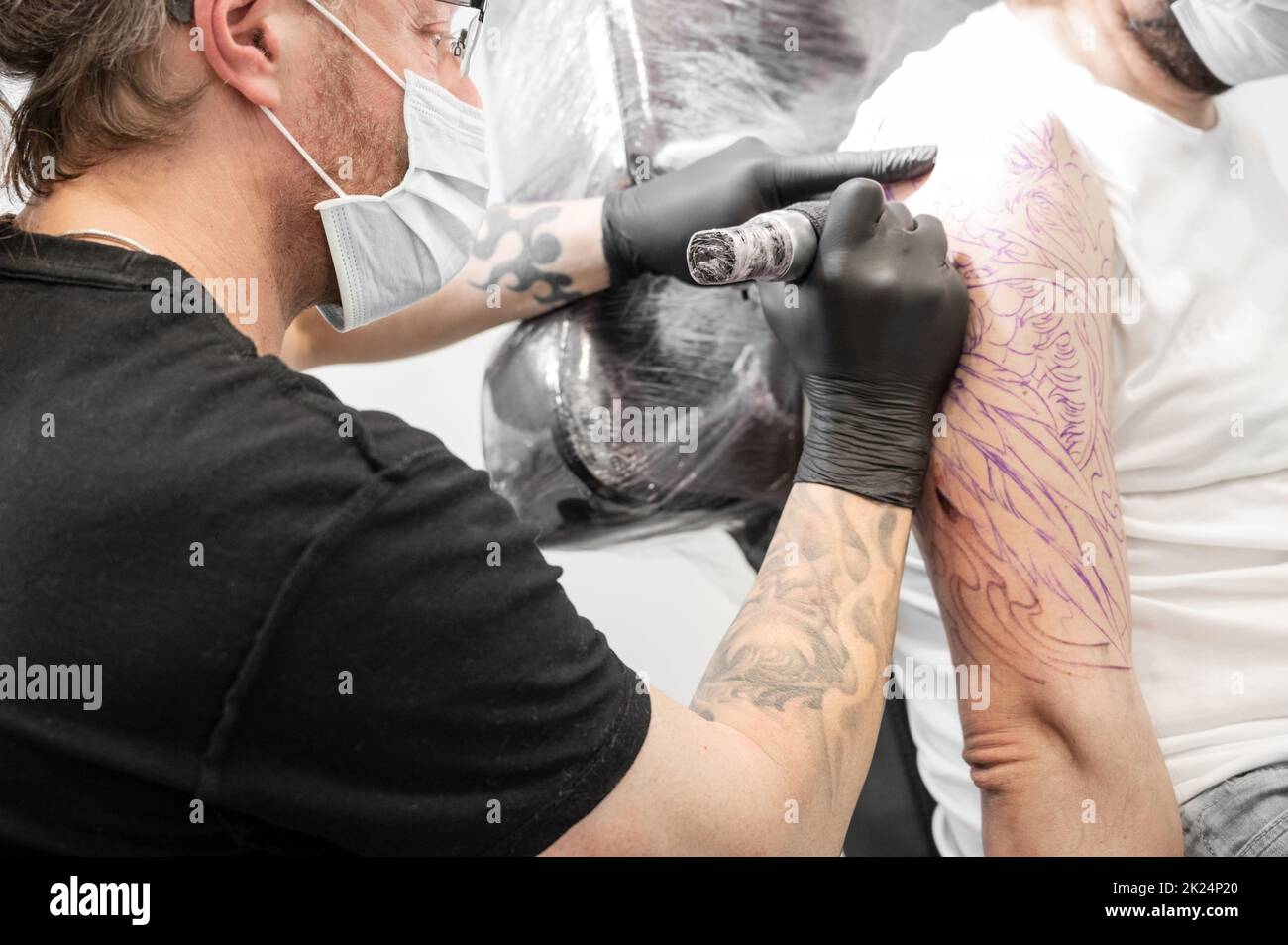 Salontätowierung. Nahaufnahme eines Tätowierers, der arbeitet. Tattoo-Künstler machen Tattoo im Studio. Hochwertige Fotografie. Stockfoto