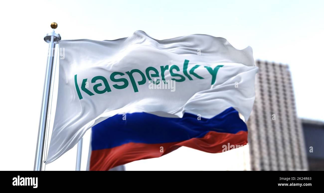 Moskau, RUS, März 2022: Weiße Flagge mit dem Logo von Kaspersky Lab, das im Wind winkt, während die russische Flagge im Hintergrund verschwommen ist. Kaspersky Lab ist ein Stockfoto