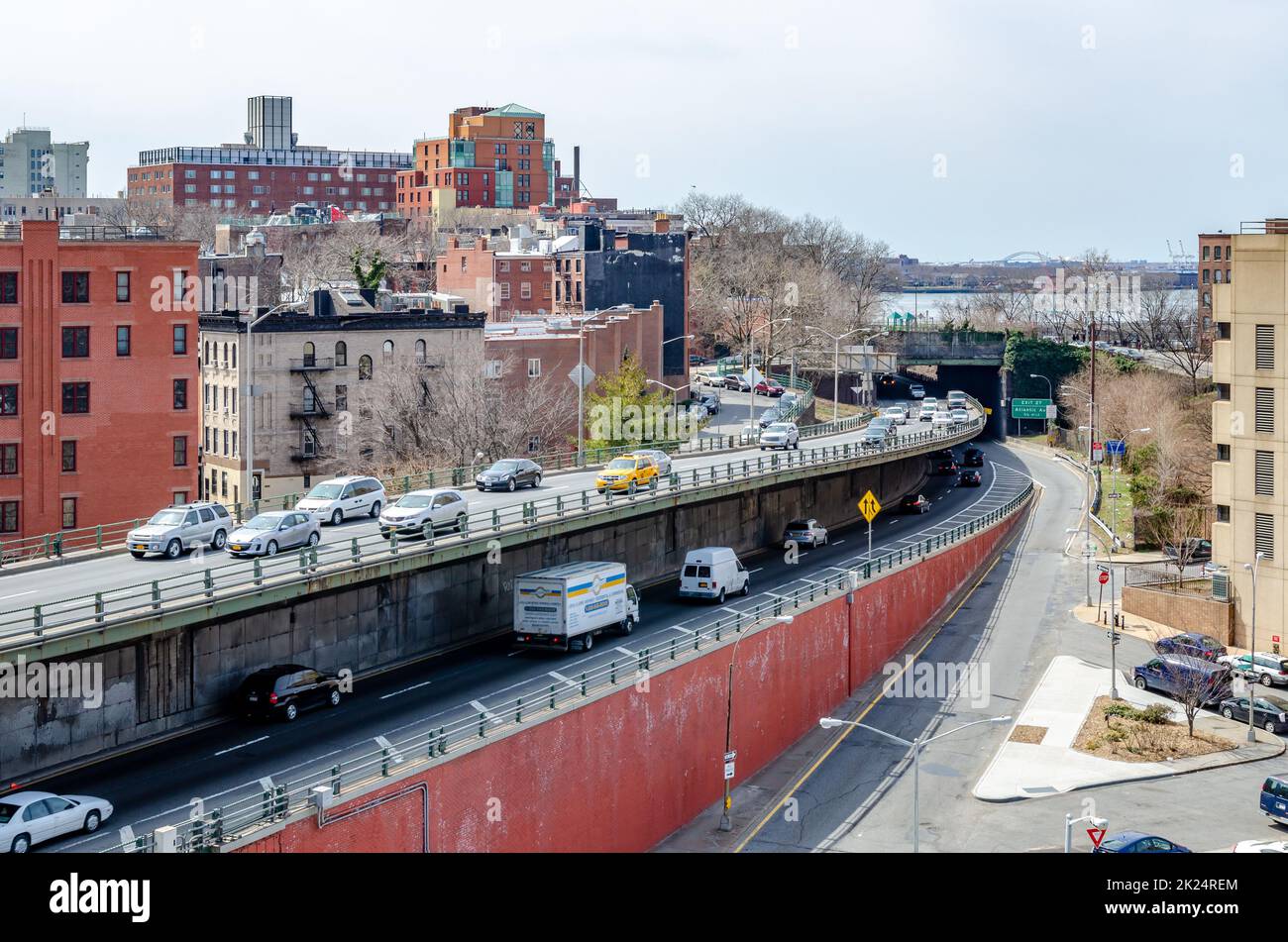 Auf den Straßenübergängen auf verschiedenen Ebenen, die die Brooklyn Bridge, Manhattan, New York City betreten und verlassen, herrscht tagsüber am Horizont viel Autoverkehr Stockfoto