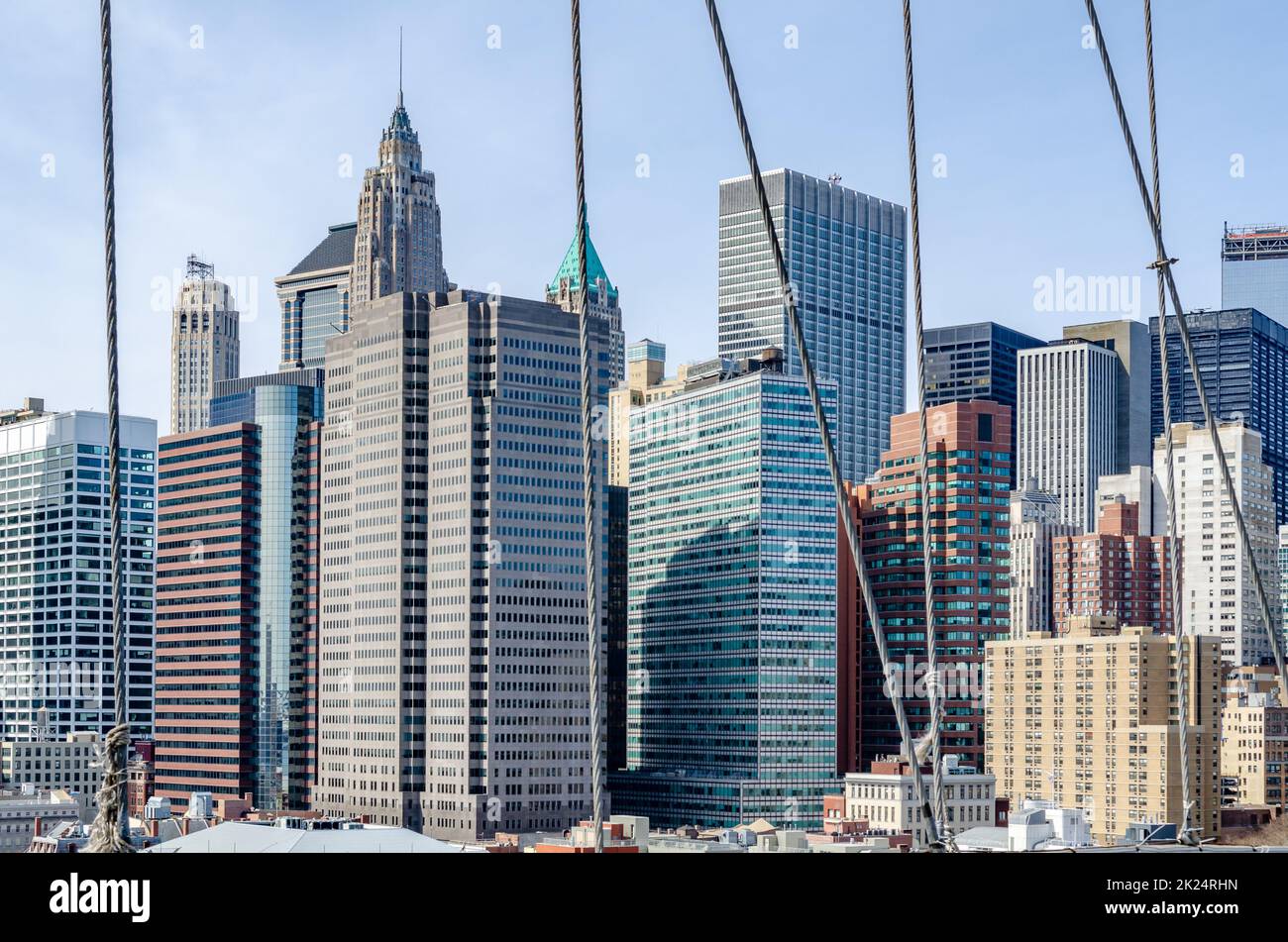 Skyline von Manhattan bei Tag mit klarem Himmel mit Drahtseilen der Brooklyn Bridge im Vordergrund, horizontal Stockfoto