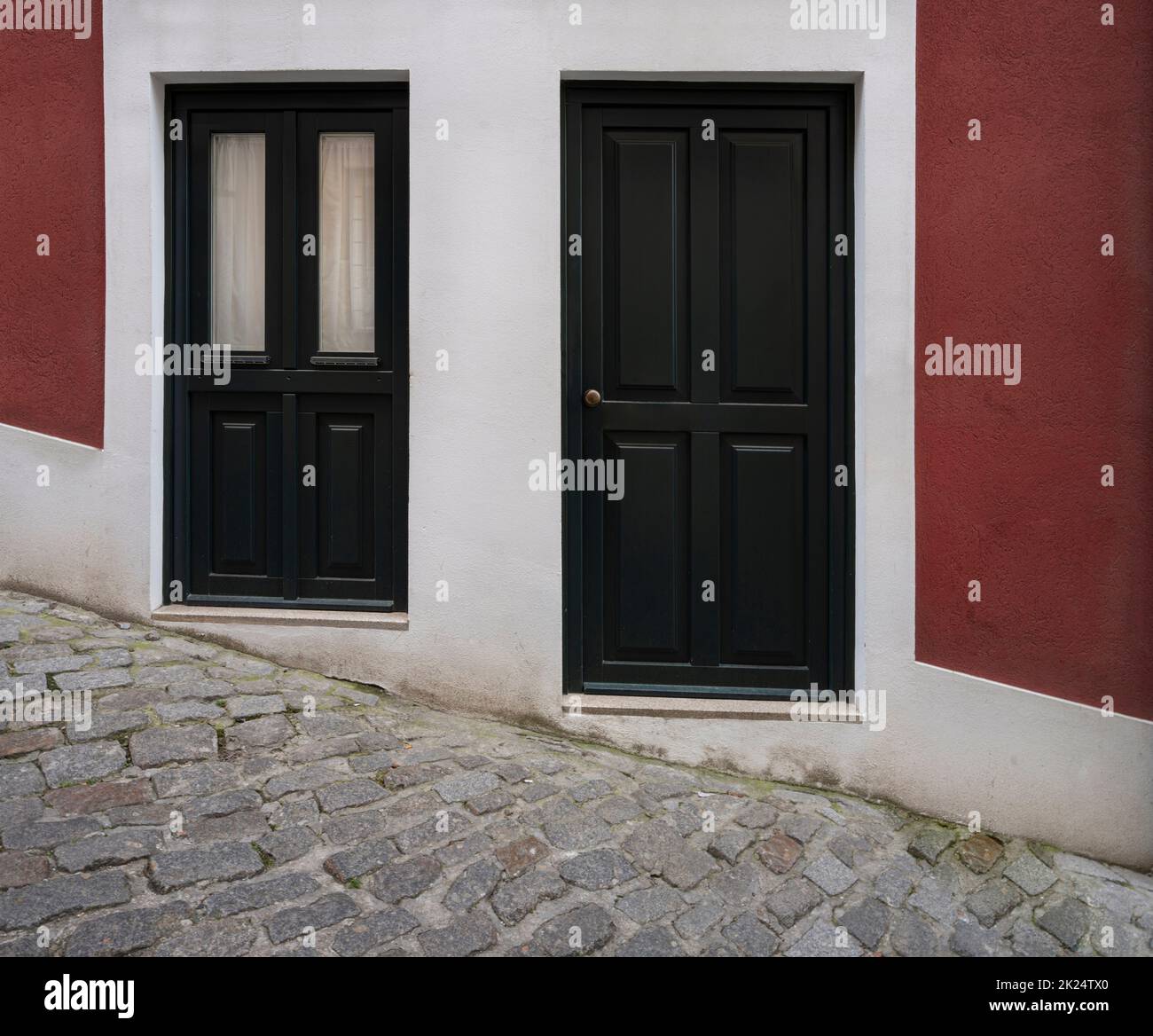 Porto, Portugal. März 2022. Die Eingangstüren zu den Häusern an der bergauf gelegenen Straße des historischen Stadtzentrums Stockfoto