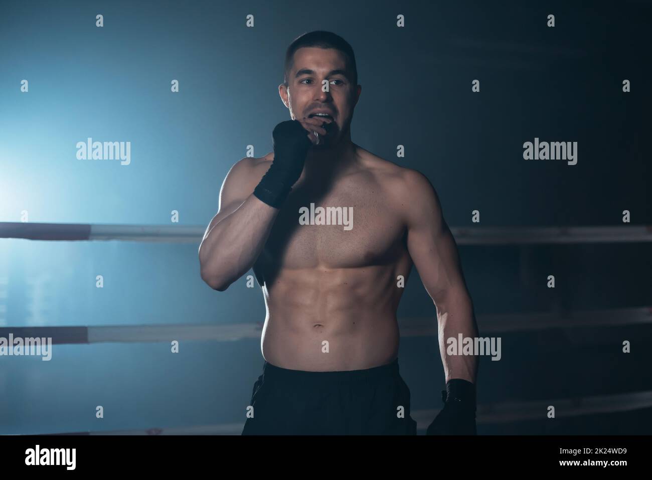 Boxer schützt den Mund der Zähne im Kampfsport. Boxer verwendet Mundschutz vor dem Kampf. Hochwertige Fotografie. Stockfoto