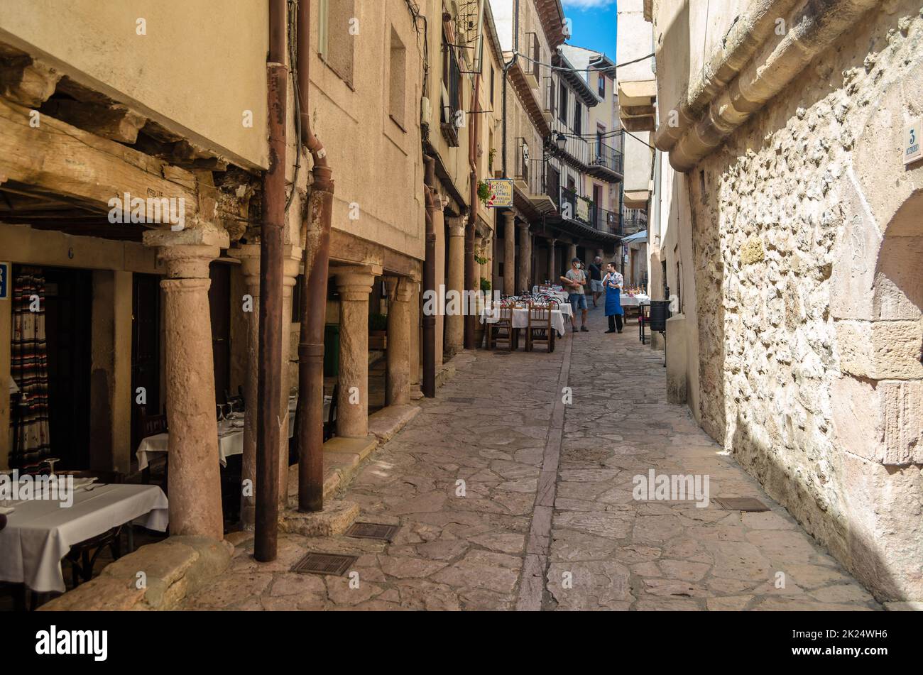 SEPULVEDA, SPANIEN - 12. SEPTEMBER 2021: Schmale Straße mit Restaurants und Terrassen, die für die Mittagszeit in der mittelalterlichen Stadt Sepulveda, Segovia p Stockfoto