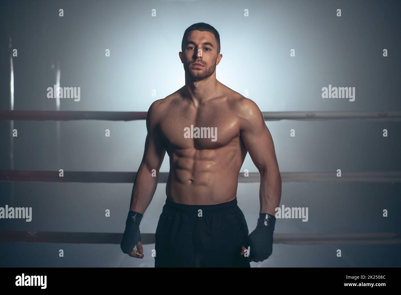 Boxer, Mann posiert in Verbandsmaterial auf Boxring. Fitness- und Boxkonzept. Hochwertige Fotos Stockfoto