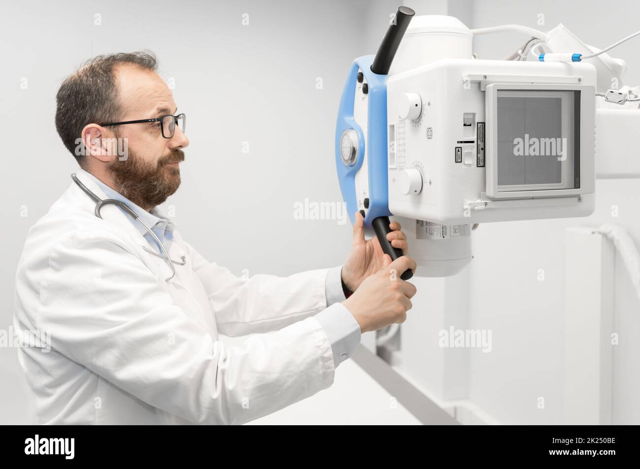 Arzt, der das Röntgengerät in der Radiologieabteilung betreibt. Hochwertige Fotografie. Stockfoto