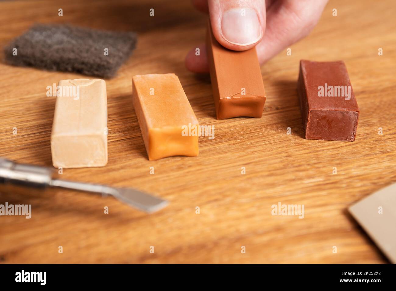 Mann passende Farbe von hartem Wachs für Reparatur Risse, Kratzer, Beulen im Holzboden. Professionelles Reparaturset Laminat oder Parkett mit Hartwachs stic Stockfoto