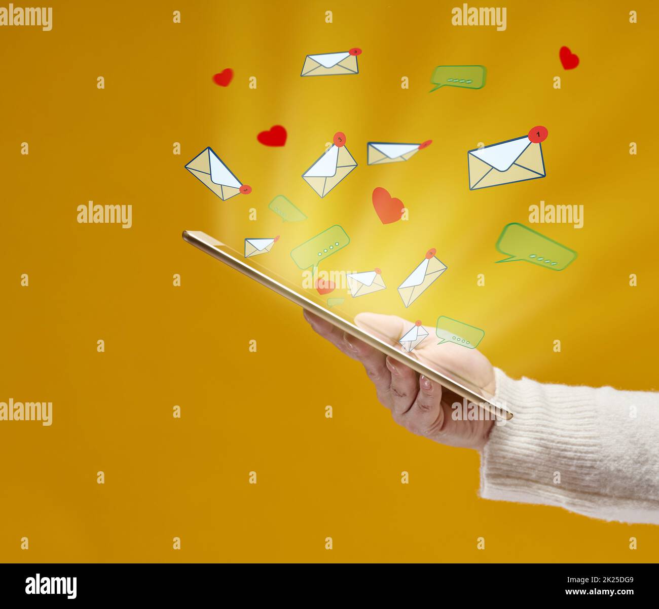 Die weibliche Hand hält ein Tablet mit ausfliegenden Herzen, Dialogen und Buchstaben auf gelbem Hintergrund. Social-Media-Abhängigkeit, Erhalt von Korrespondenz und Beurteilung. Multitasking Stockfoto