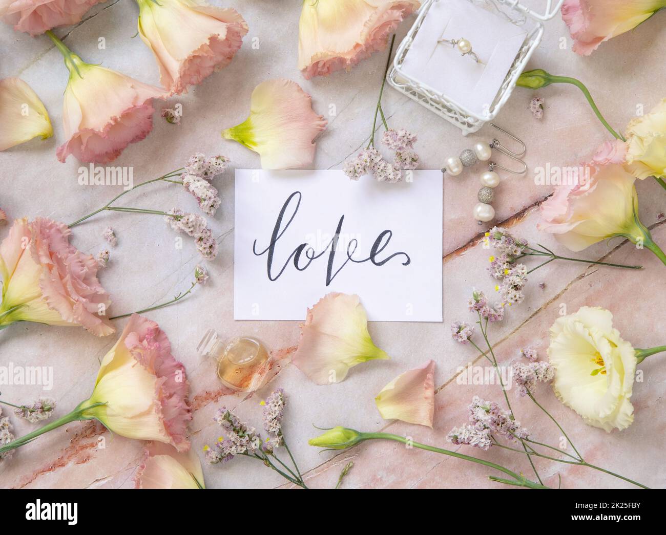 Karte mit dem Text LIEBE umgeben von rosa Blumen Stockfoto