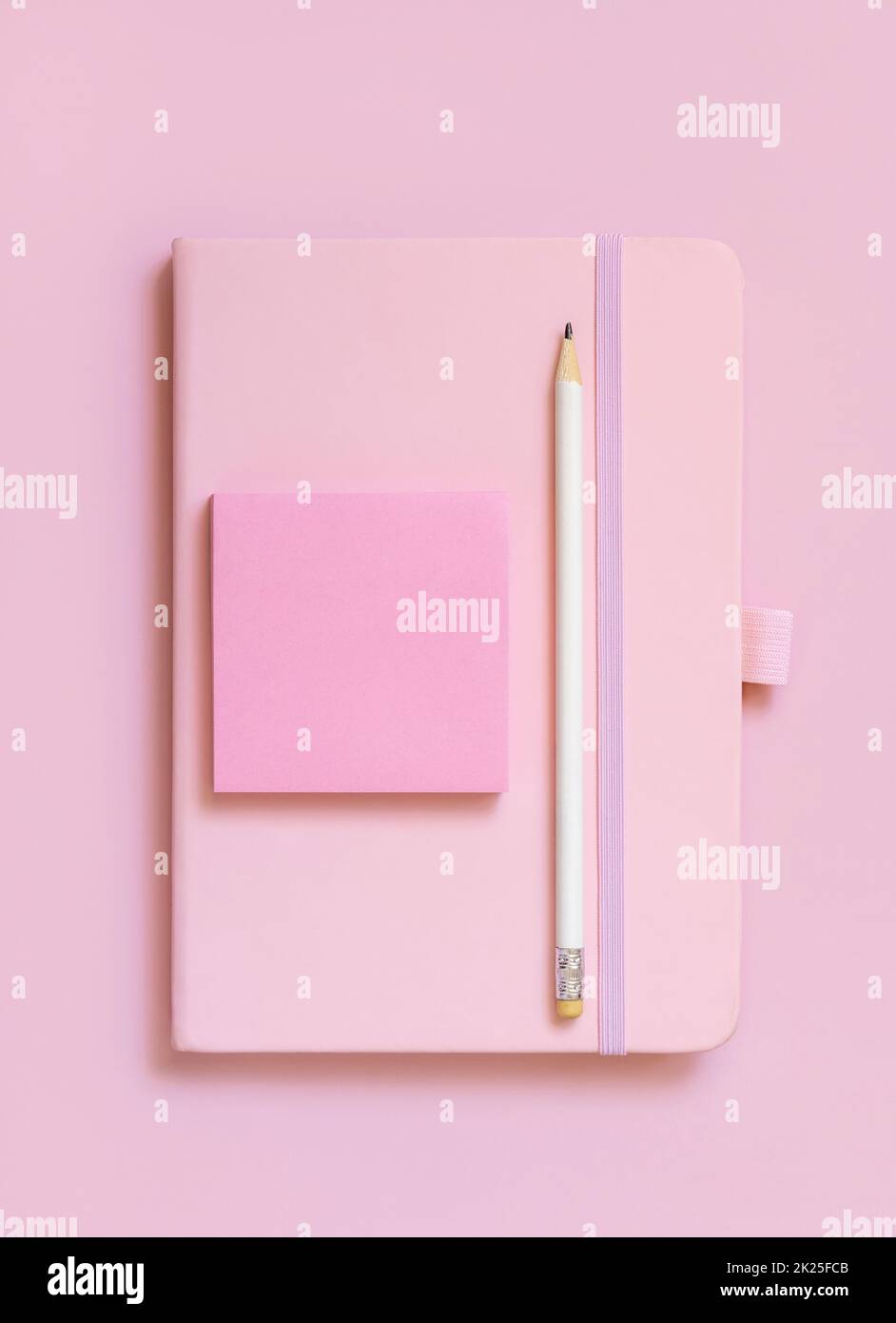 Pinkfarbenes Notizbuch, Bleistift und Papier auf hellrosa Draufsicht Stockfoto
