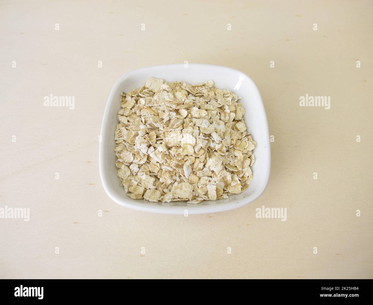 Fein gerollte Haferflocken auf einem Holzbrett Stockfoto