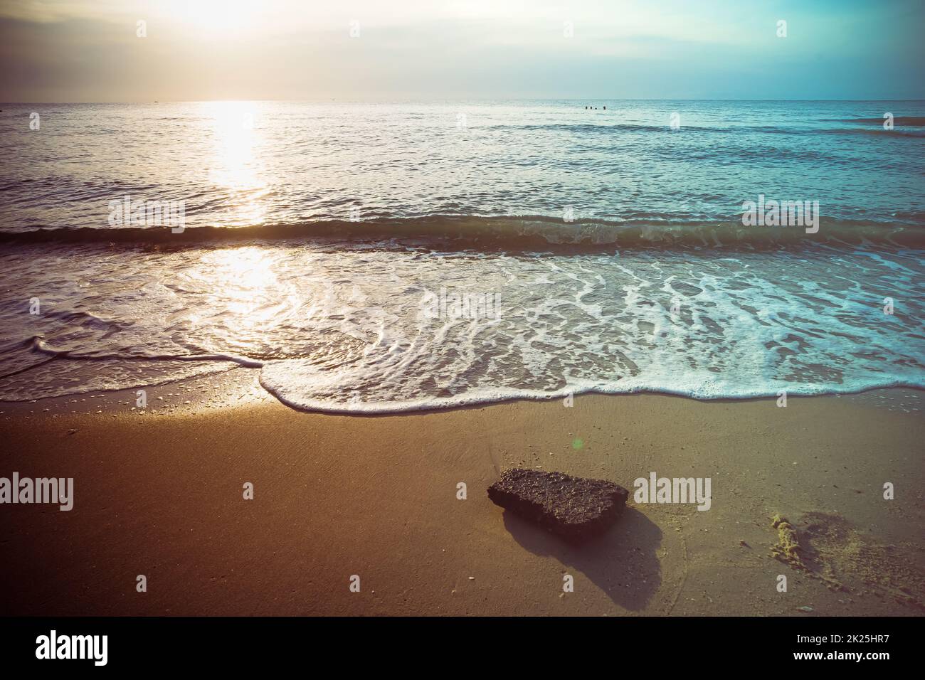 Sanfte blaue Wellen am Strand im Sommer. Meeresstrand blauer Himmel, Sonne, Tageslicht, Relaxationslandschaft Aussichtspunkt. Die Farbe des Wassers und das wunderbar helle, klare Wasser. Stockfoto