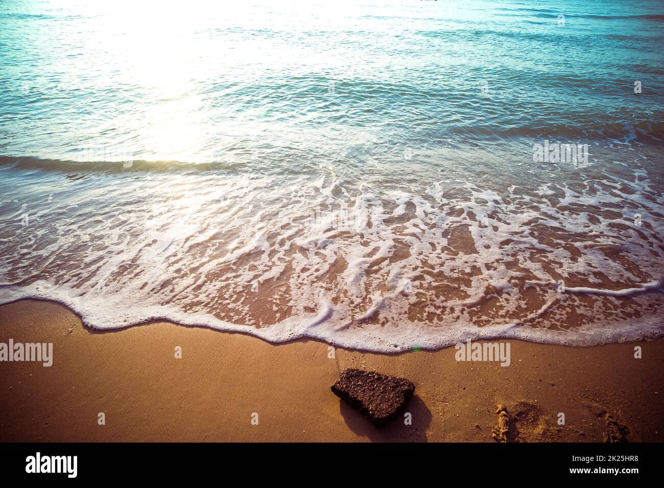 Sanfte blaue Wellen am Strand im Sommer. Meeresstrand blauer Himmel, Sonne, Tageslicht, Relaxationslandschaft Aussichtspunkt. Die Farbe des Wassers und das wunderbar helle, klare Wasser. Stockfoto