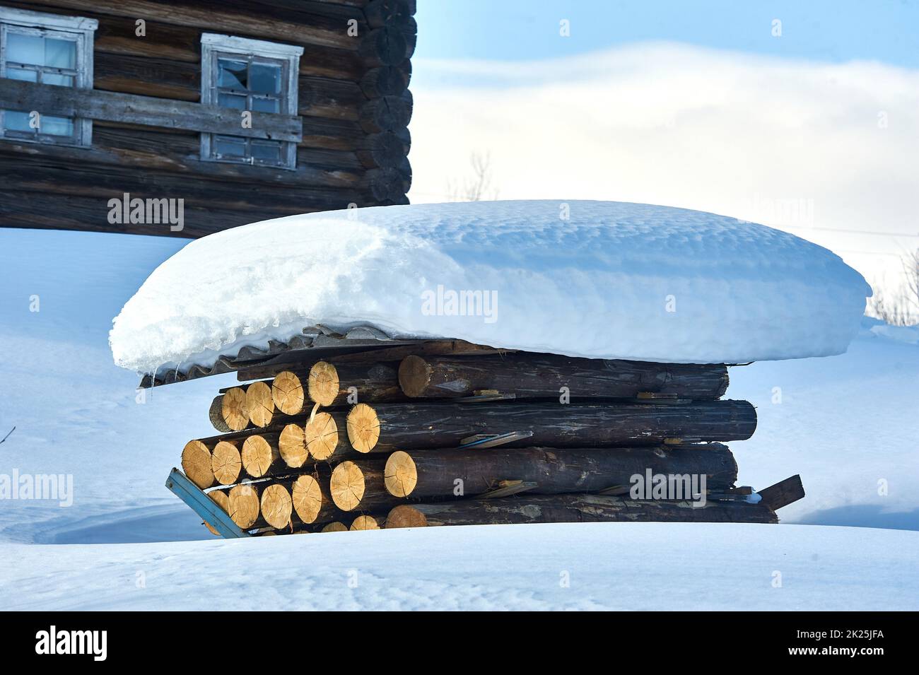 Ein Stapel von Baumstämmen mit Schiefer unter dem Schnee bedeckt Stockfoto