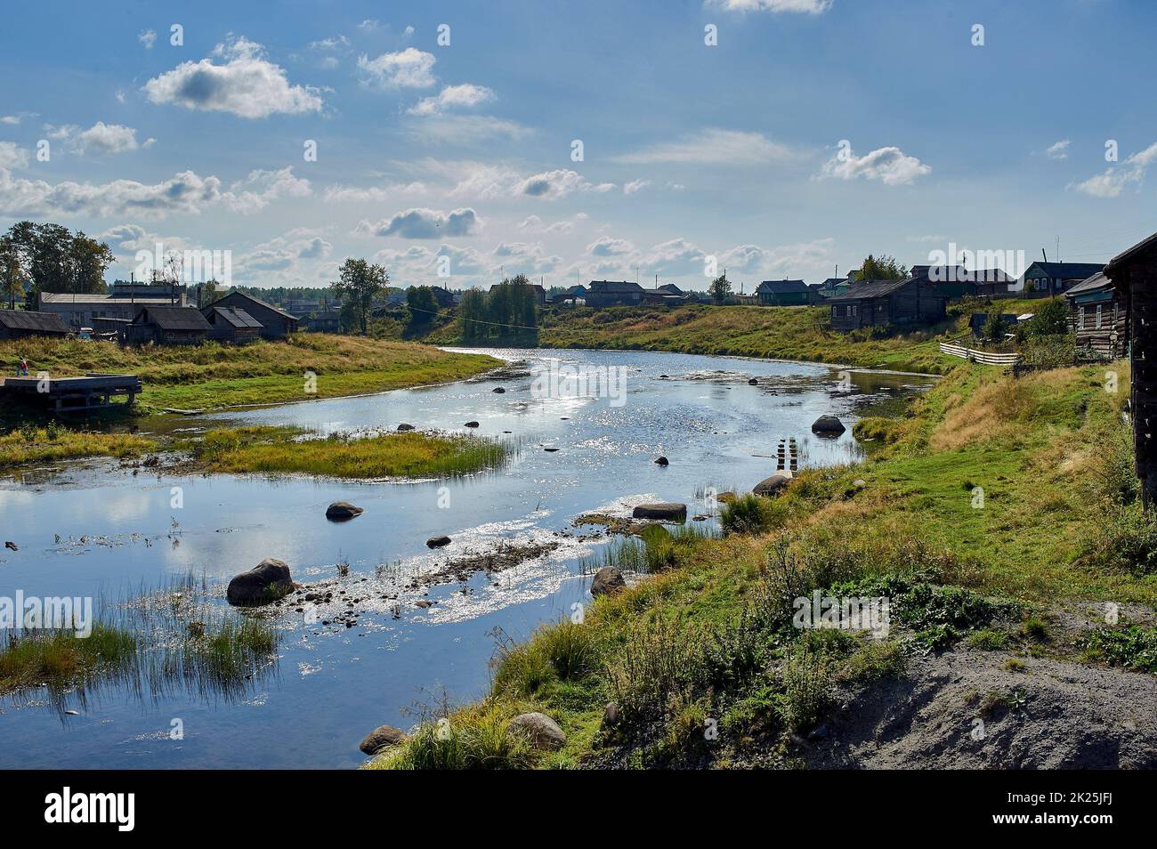 Flacher Fluss im Hintergrund des Dorfes Stockfoto