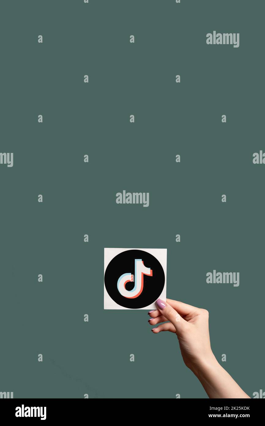Kharkiv, Ukraine - 05. Juni 2020: TikTok-Ikone. Soziale Medien. Online-Unterhaltung. Weibliche Hand zeigt Musik Anwendungsschild isoliert auf dunkel blaugrün Stockfoto