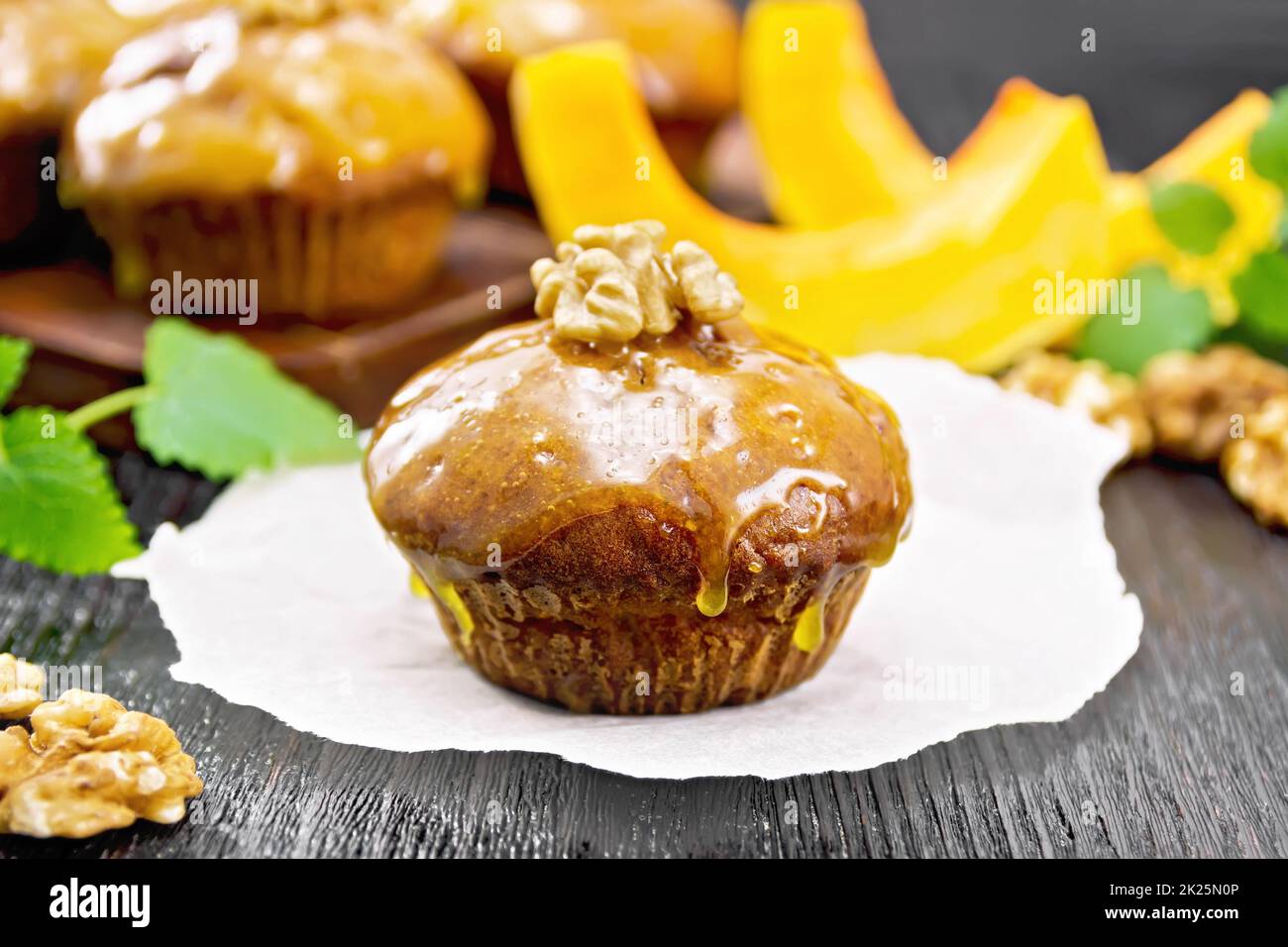 Cupcake Kürbis mit Orangenglasur und Walnüssen auf dunklem Brett Stockfoto