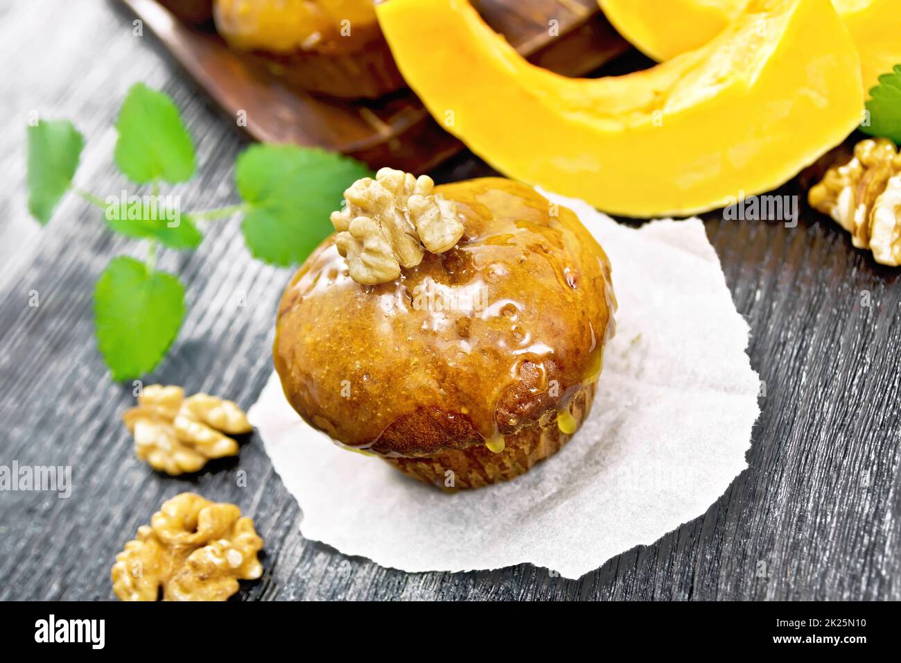 Cupcake-Kürbis mit Orangenglasur und Walnüssen auf Pergament Stockfoto