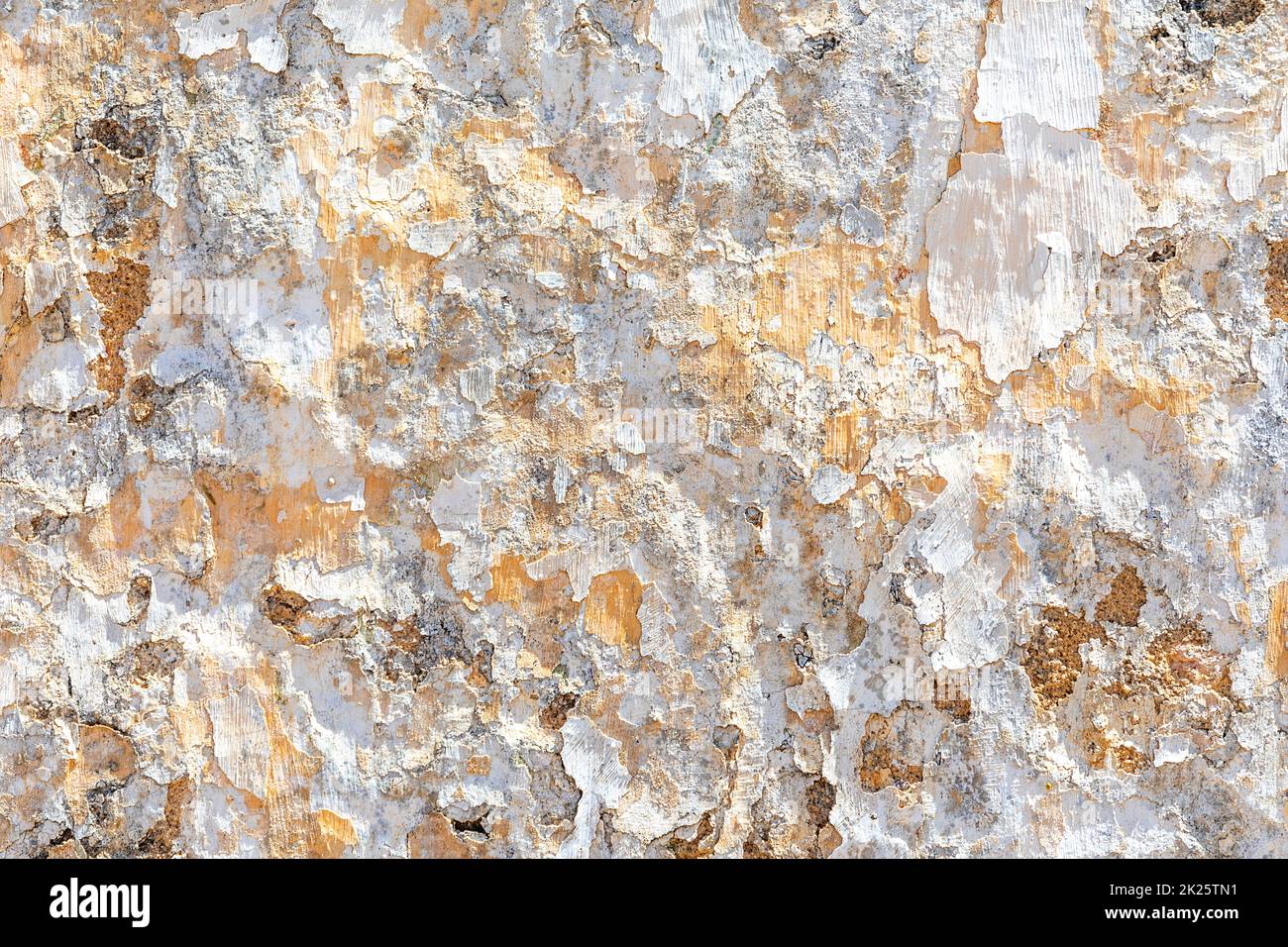 Hintergrund der alten Putzwand mit abblätternden Farben in Weiß und Orange Stockfoto