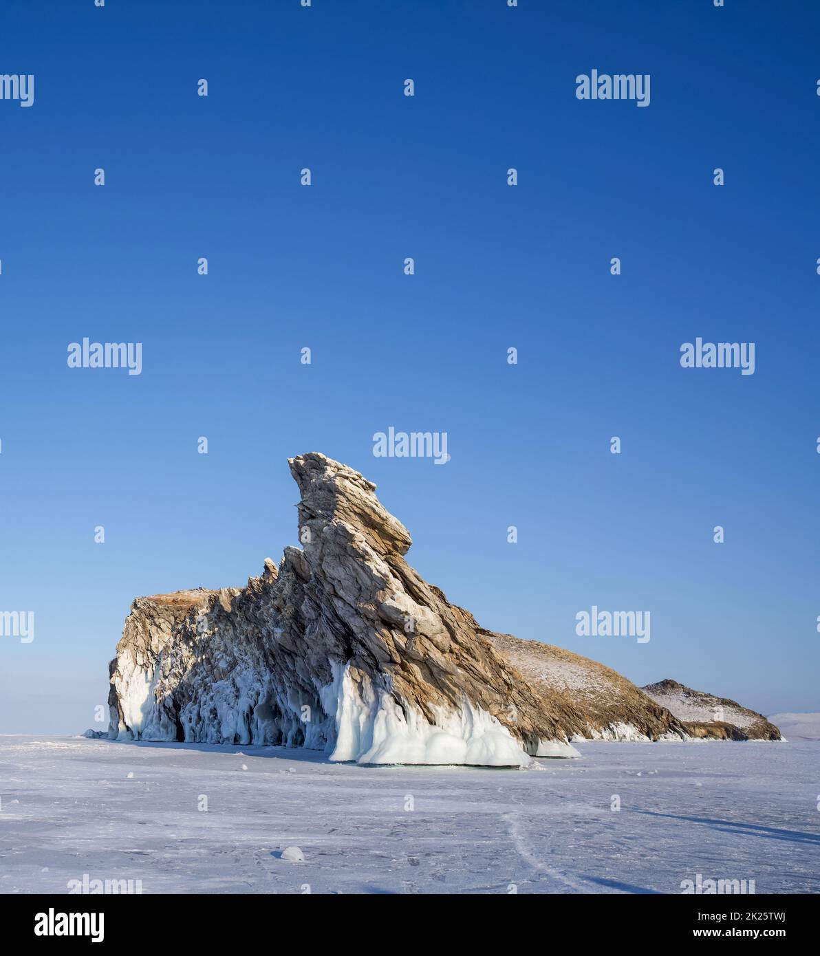 Ogoy, die größte Insel in der Maloe More Meerenge des Baikalsees. Ein langgestreckter Felsberg auf einem gefrorenen See vor der Winterkälte. Stockfoto