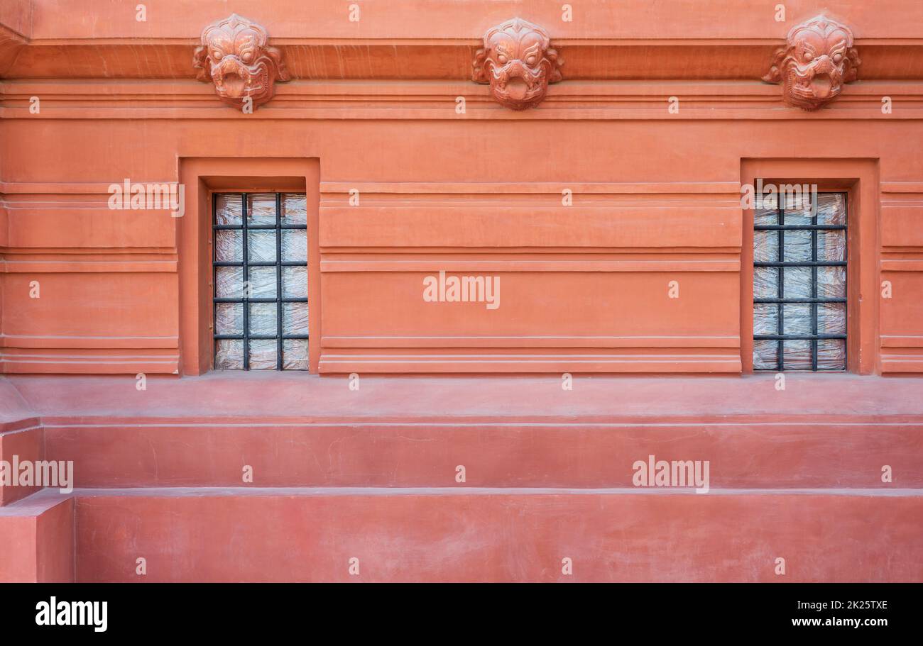 Zwei schmiedeeiserne Gitterfenster in der Zierwand außerhalb des alten Steingebäudes Stockfoto Zwei schmiedeeiserne Gitterfenster in der Zierwand außerhalb des alten Steingebäudes Stockfoto