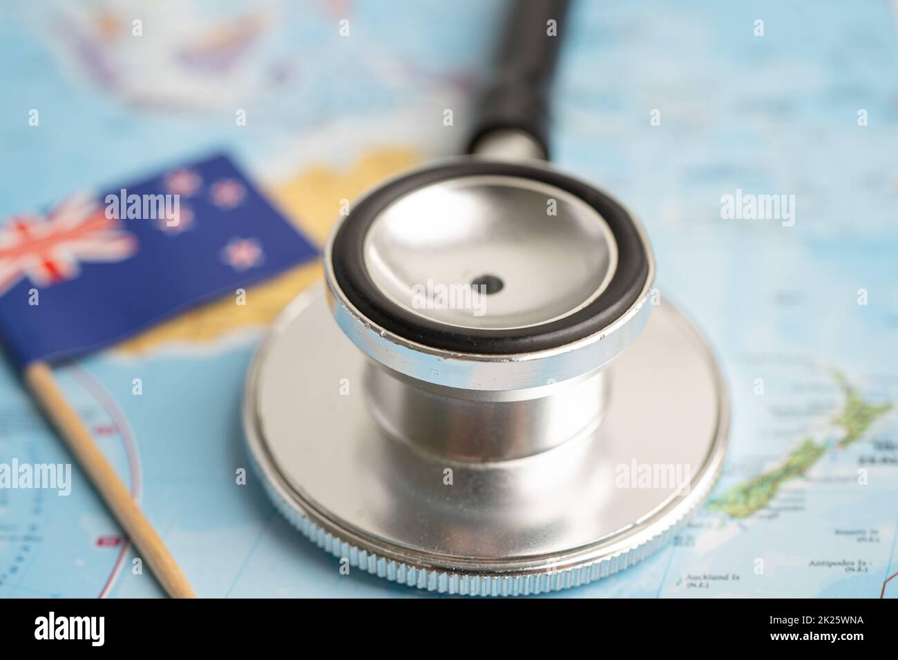 Schwarzes Stethoskop mit neuseeländischer Flagge im Hintergrund der Weltkarte, Geschäfts- und Finanzkonzept. Stockfoto
