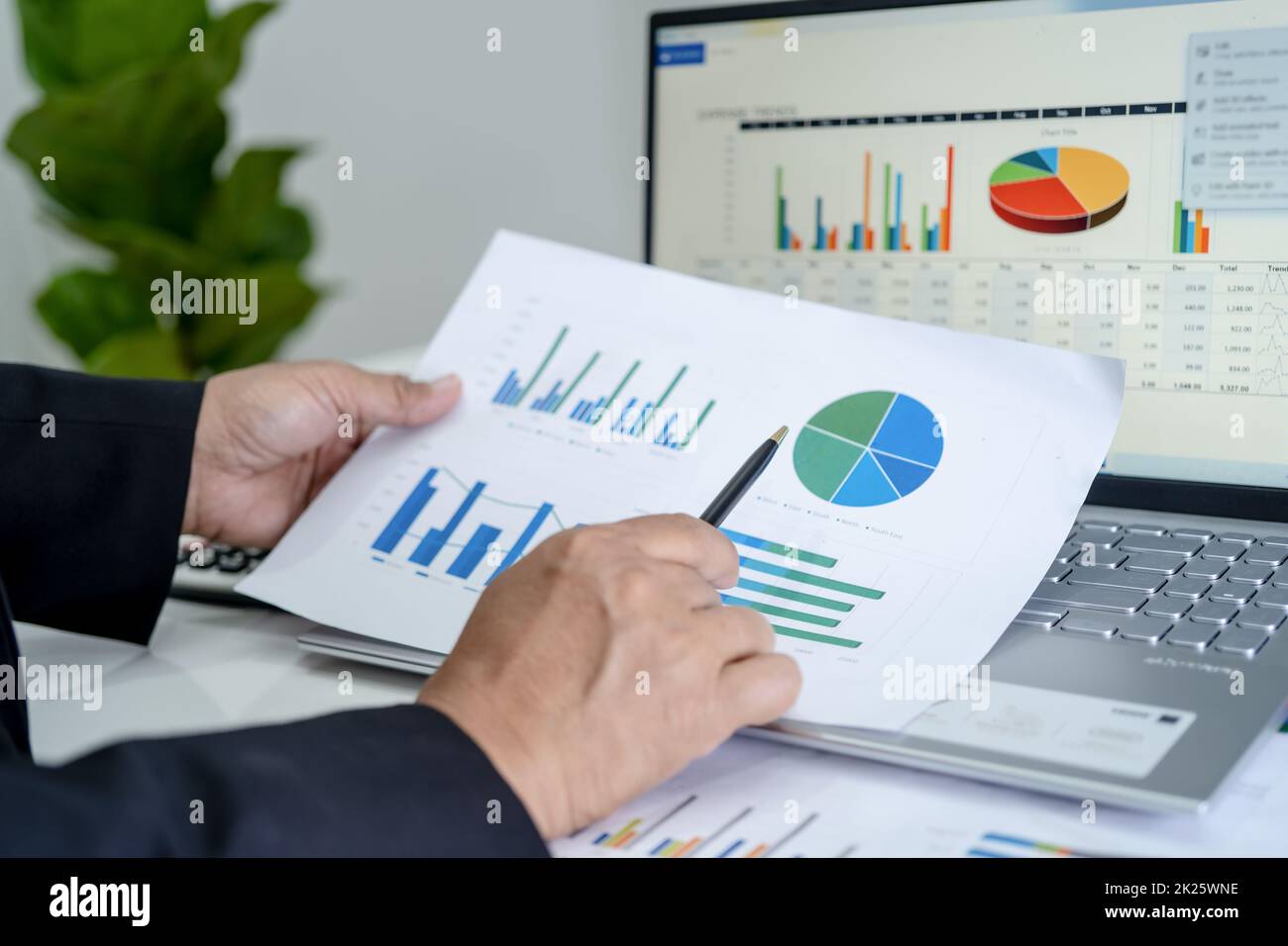 Asiatischer Buchhalter arbeitet und analysiert Finanzberichte ...