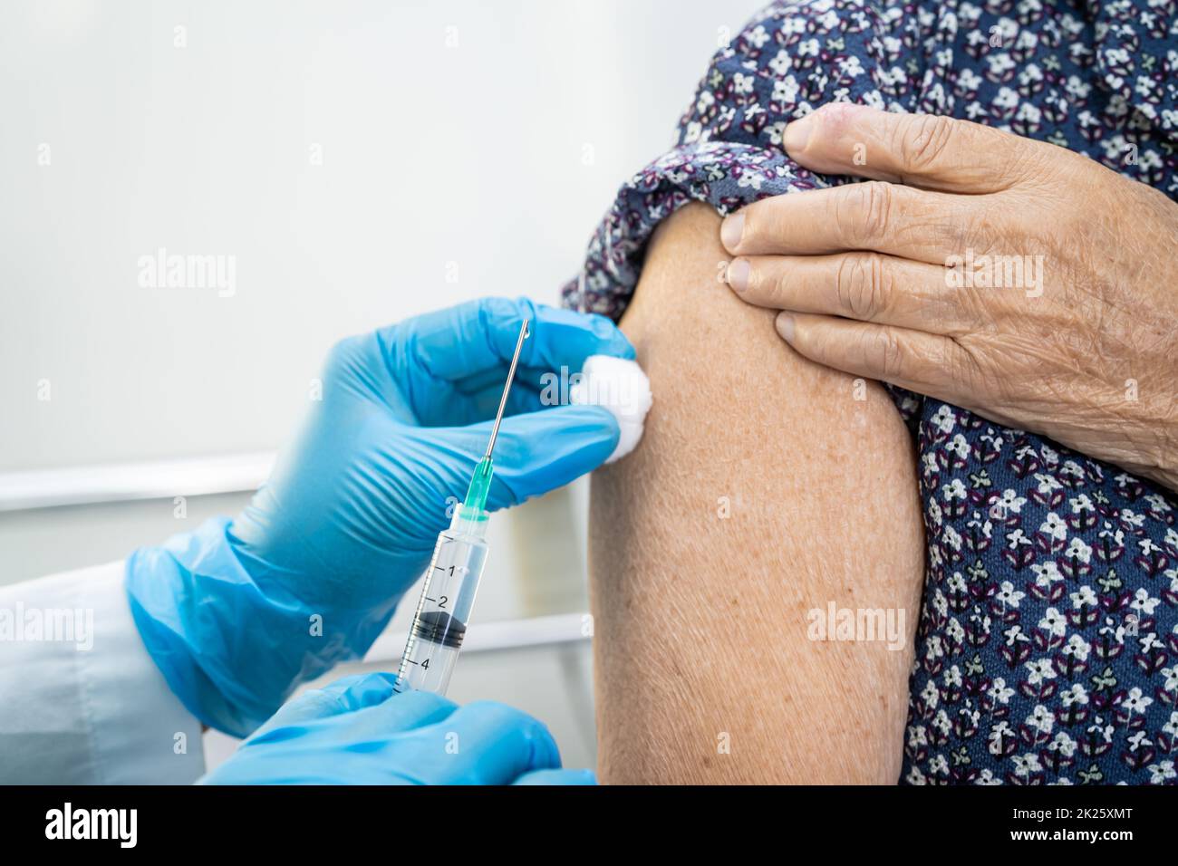 Ältere asiatische ältere Frau, die vom Arzt einen Covid-19- oder Coronavirus-Impfstoff erhält, wird mit einer Injektion geimpft. Stockfoto