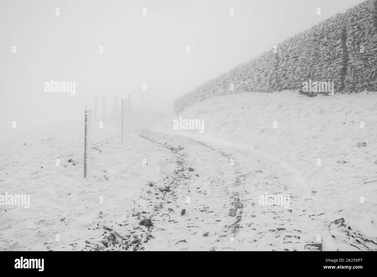 Winterstraße bergauf bei schlechtem Wetter. Winterlandschaft. Stockfoto