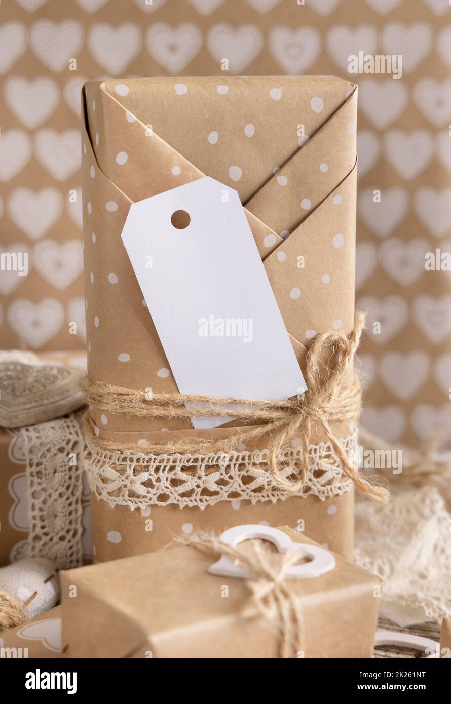 Valentinsgeschenk mit leerem Geschenkanhänger und Herzen aus der Nähe, Rustic Label Mockup Stockfoto