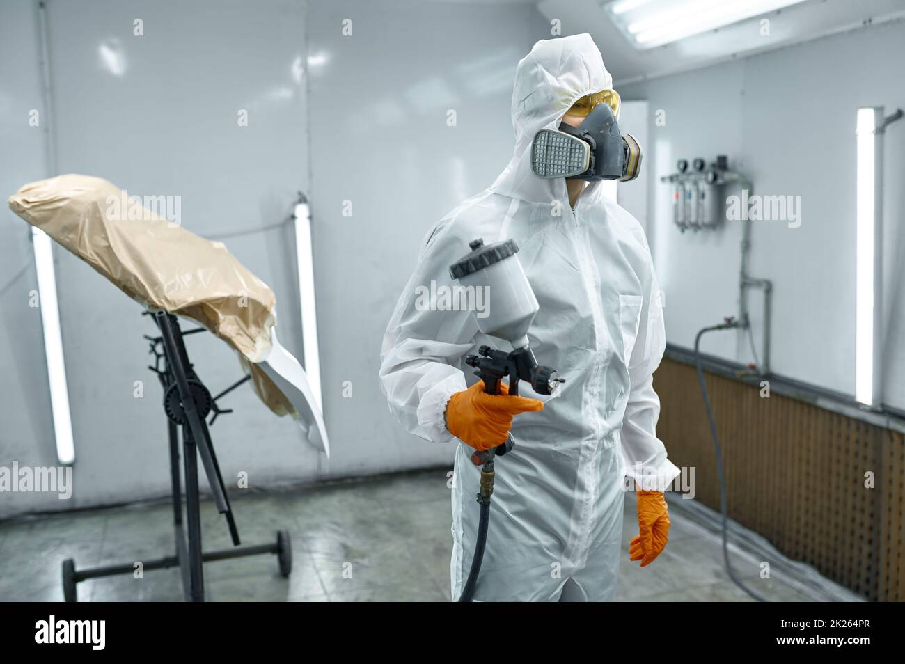 Automechaniker verlässt nach der Arbeit die Lackierkammer Stockfoto