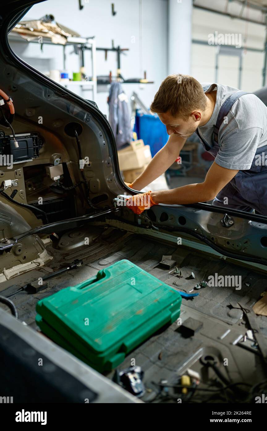 Befestigungsschraube des Werkers während der Karosseriereparatur Stockfoto