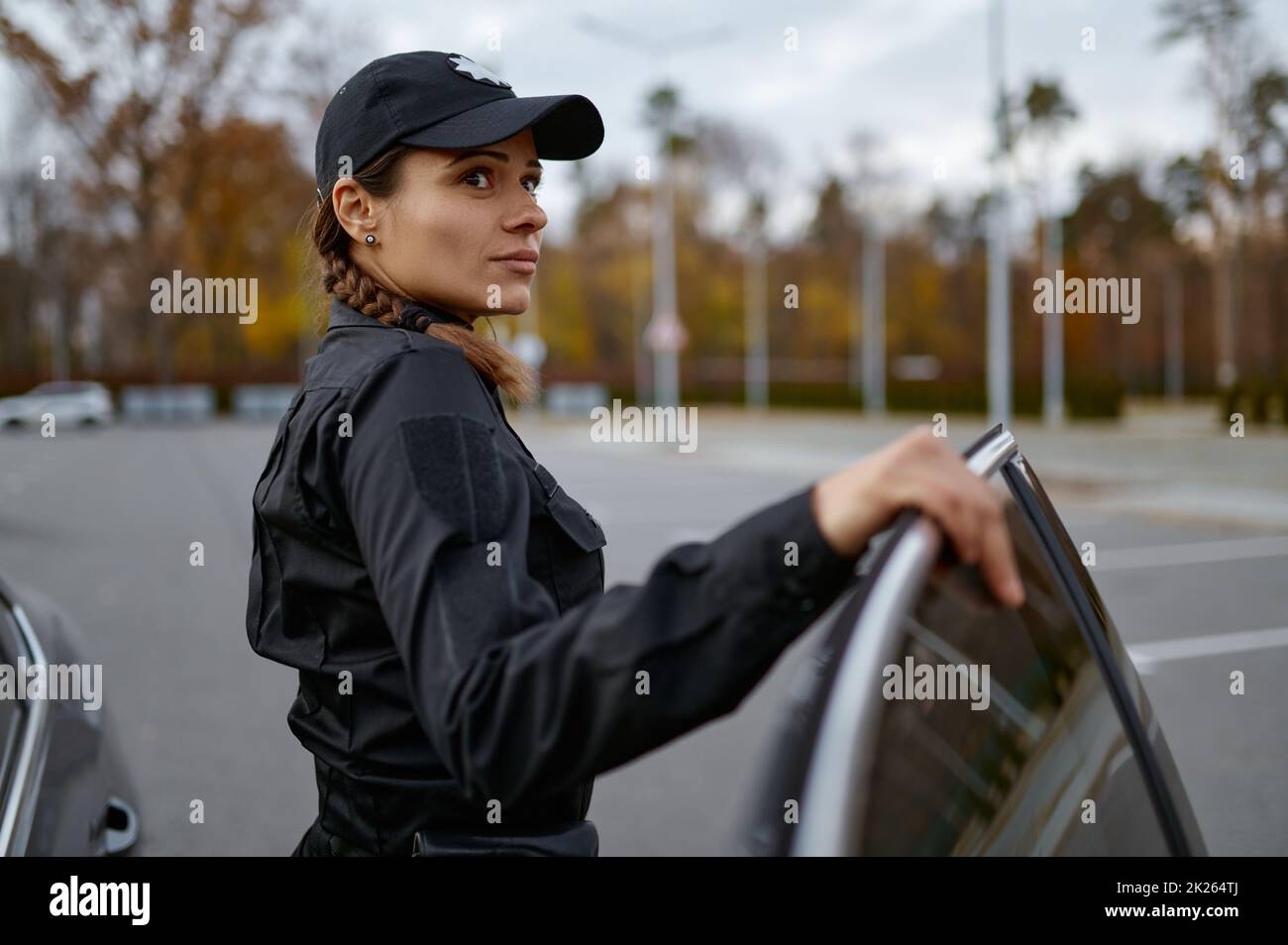 Polizeifrau in Uniform in der Nähe von Autoporträt Stockfoto