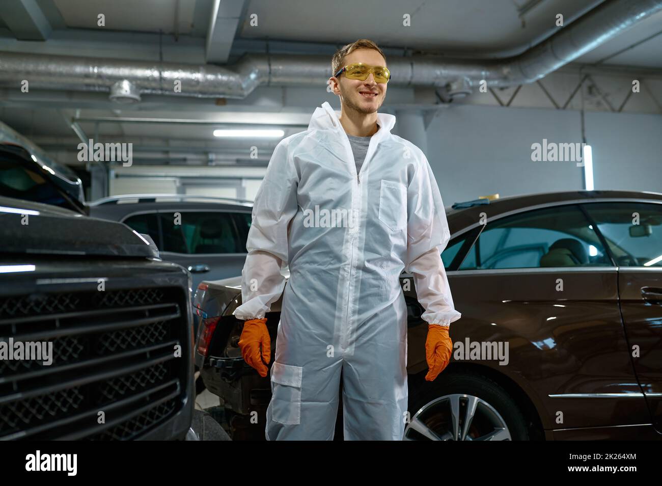 Junger zufriedener Lackmeister in der Autogarage Stockfoto