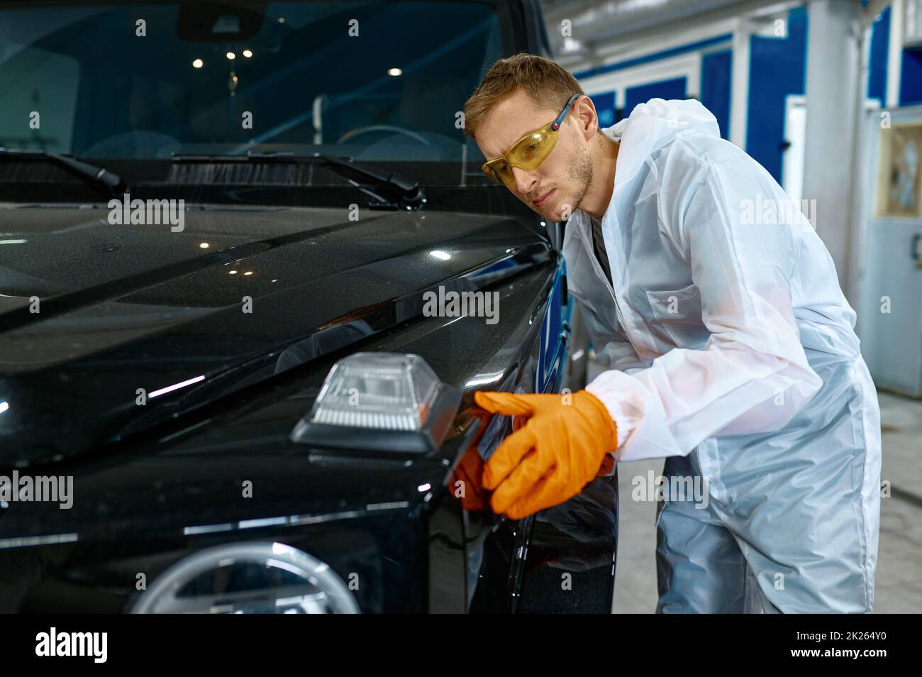 Seriöse Werkstatt, die die Lackierqualität des Fahrzeugs überprüft Stockfoto