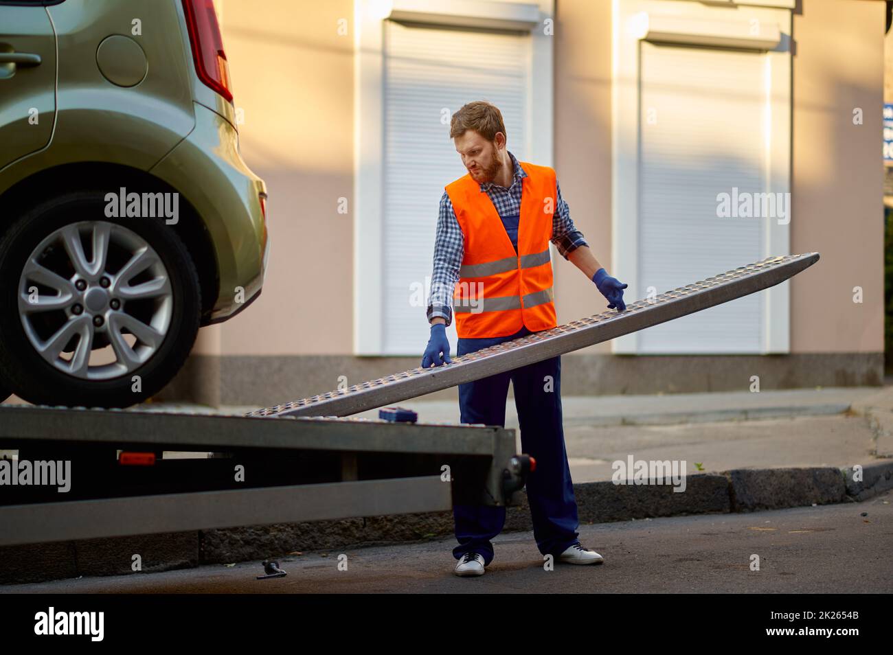 Arbeiter, der die Plattform des Abschleppwagens für das Auto vorbereitet Stockfoto