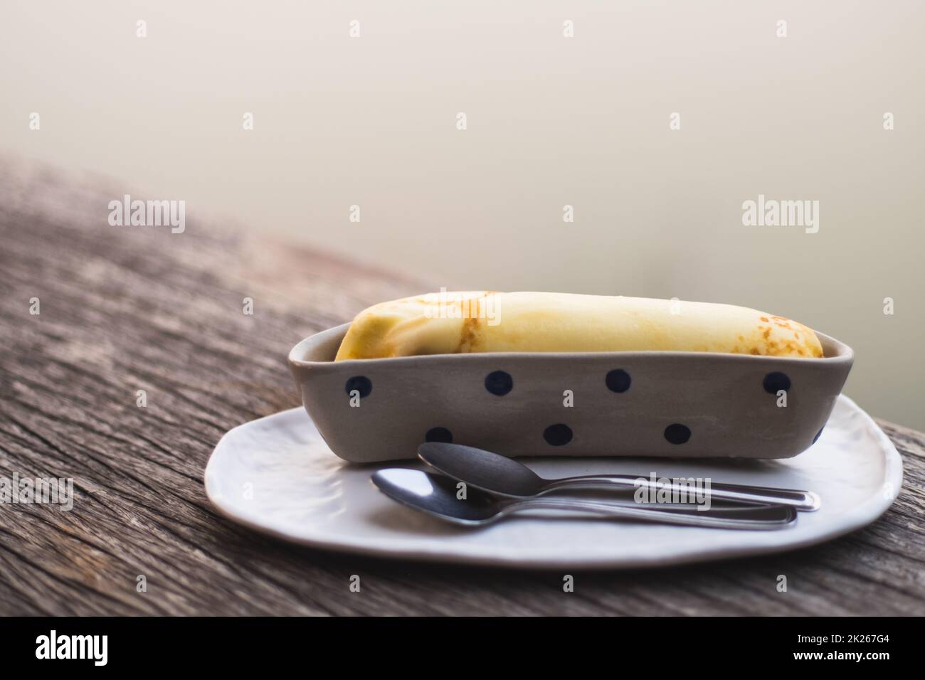 Banana Crepe süß Dessert Objekt Stillleben. Die Kreppe in die Keramik-Behälter Schüssel Bananenform Form Design. Stockfoto