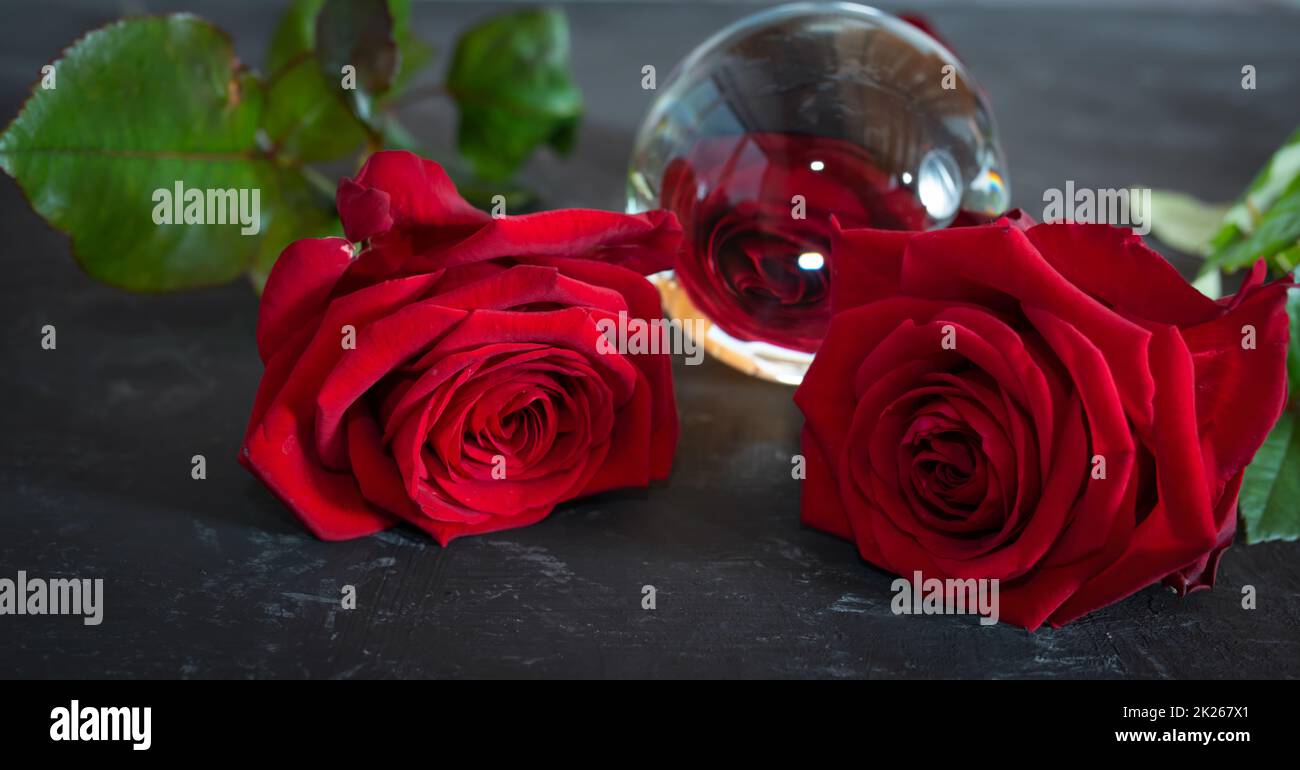 Rote Rosen spiegeln sich in einer Glaskugel wider Stockfoto